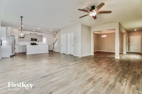 A spacious room with a ceiling fan and wooden flooring.