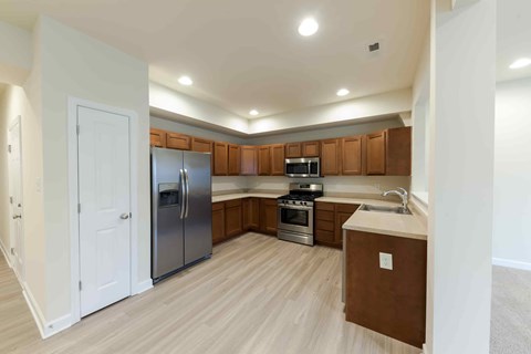 A kitchen with wooden cabinets and a white fridge.
