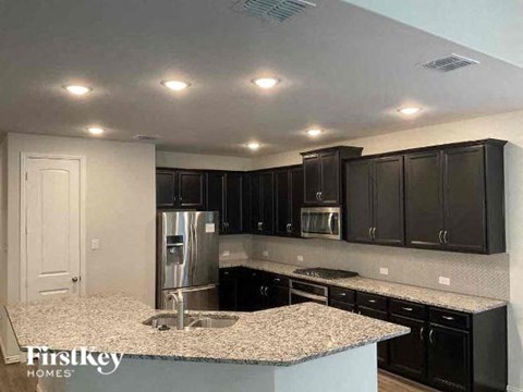 a kitchen with black cabinets and a granite counter top
