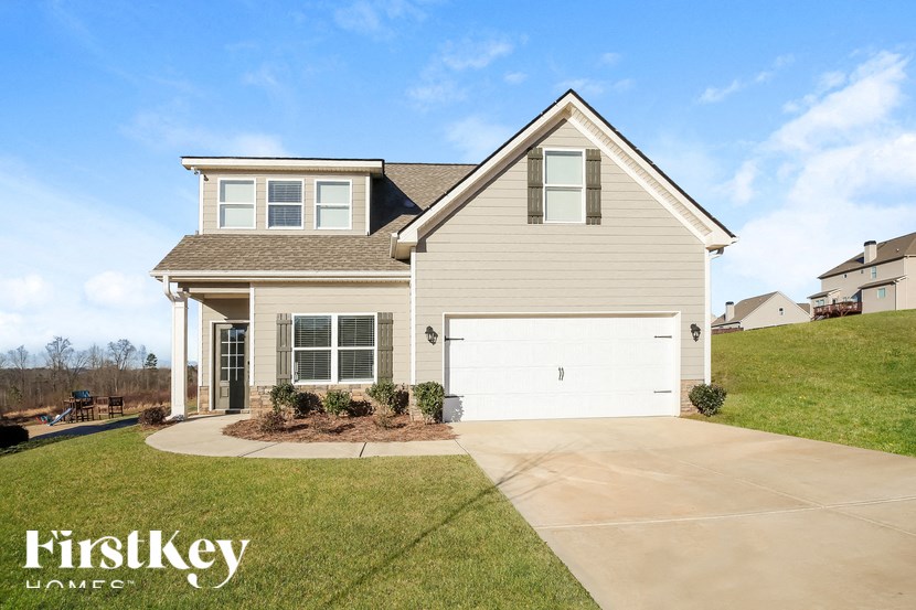 A house with a garage and a driveway in front of it.