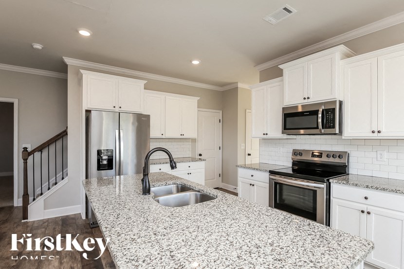 A kitchen with granite countertops and stainless steel appliances.