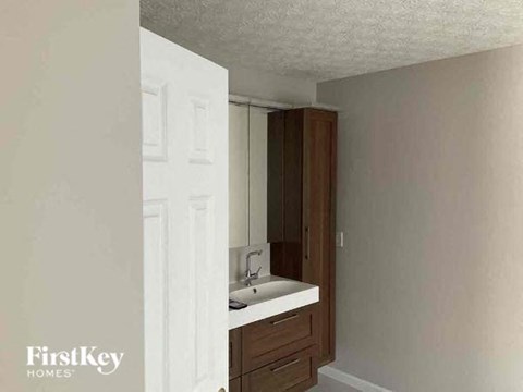 A bathroom with a white door and a brown cabinet.