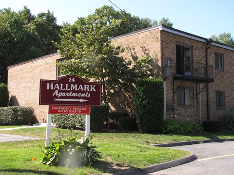a building with a hallmark apartments sign in front