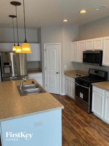 A kitchen with a sink and a stove top oven.