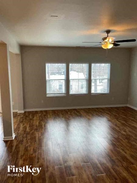 A room with wooden floors and a ceiling fan.