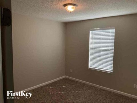 an empty room with a window and a light on the ceiling