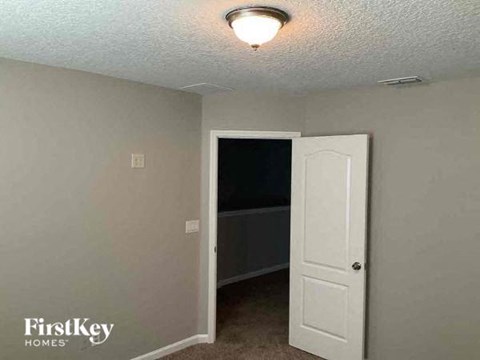 a bedroom with a white door and a closet