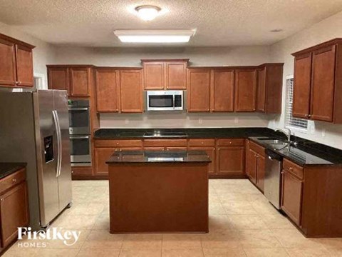 a large kitchen with wooden cabinets and stainless steel appliances