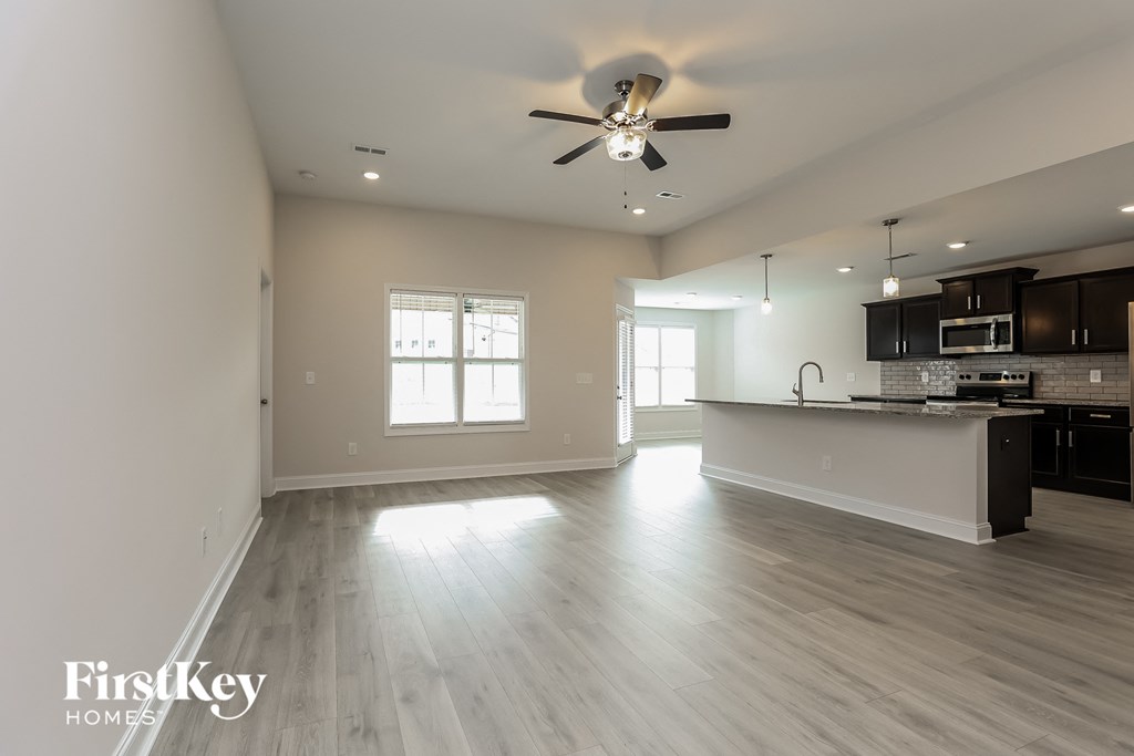 an empty kitchen and living room with a ceiling fan