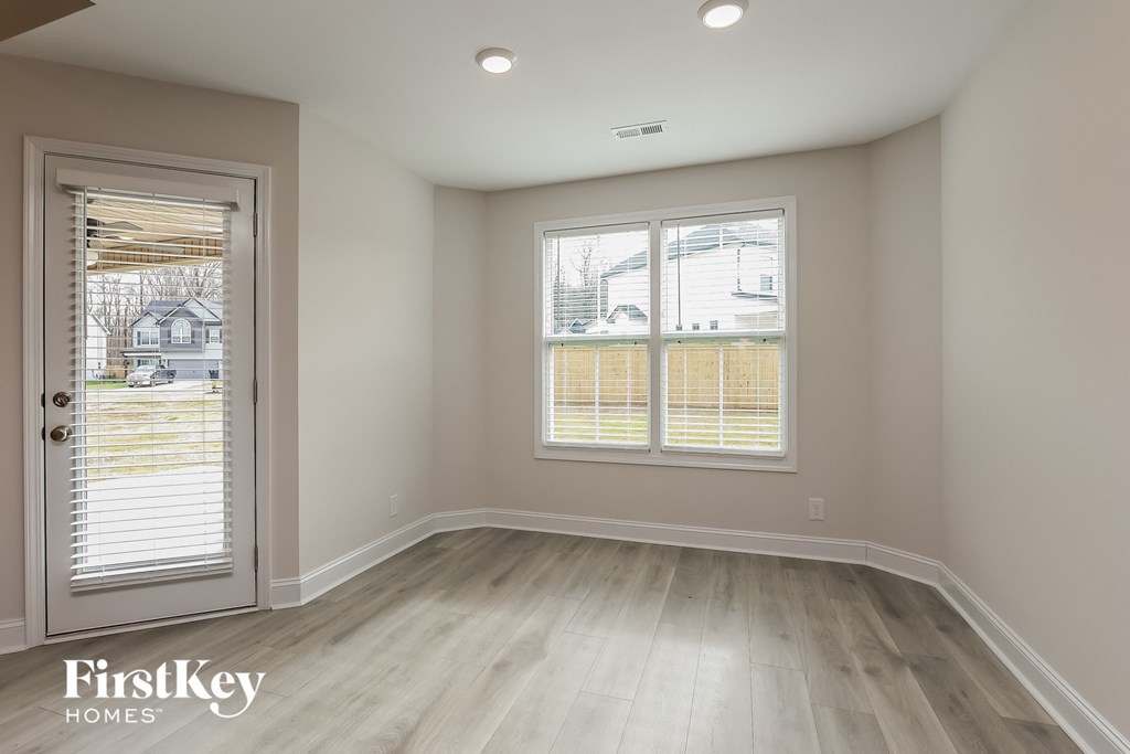 an empty room with a door and two windows