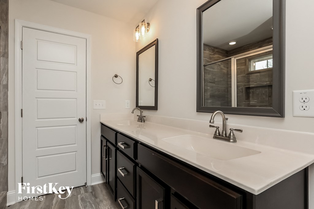 a bathroom with a sink and a mirror and a white door