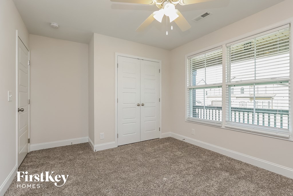 a bedroom with a ceiling fan and a window