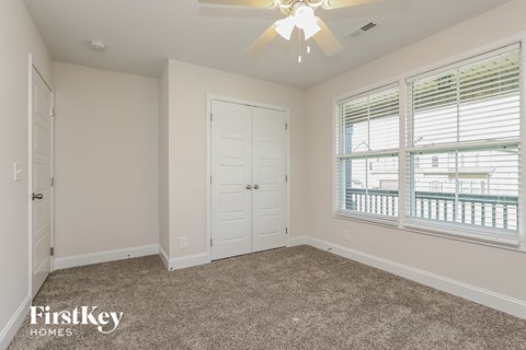 a bedroom with a ceiling fan and a window