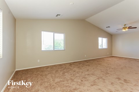 a living room with carpet and a ceiling fan