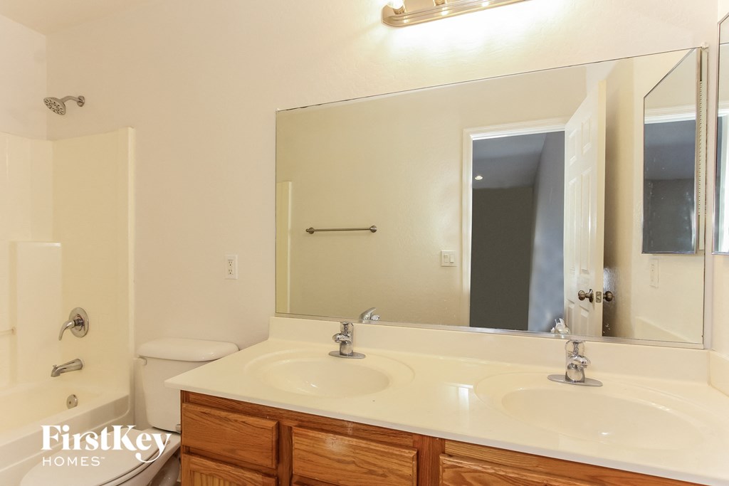 a bathroom with two sinks and a large mirror