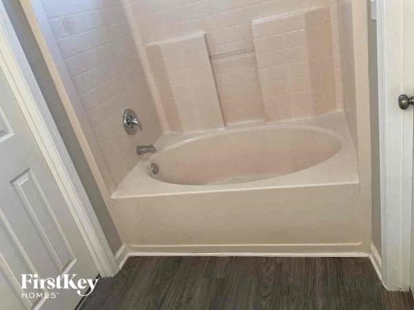 a white bath tub in a bathroom with a door