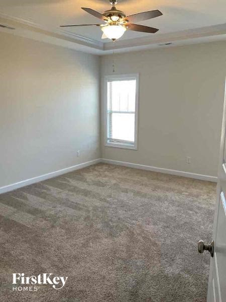 an empty room with a ceiling fan and a window