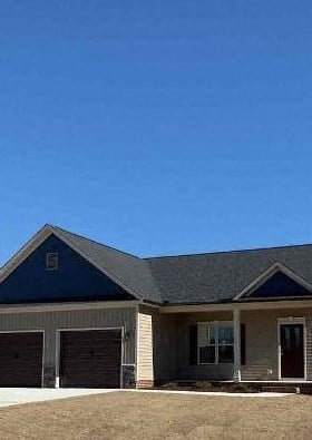 a house with two garage doors and a yard