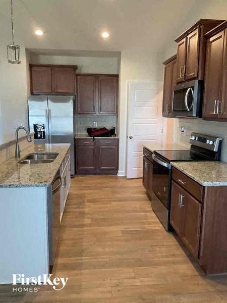 a kitchen with stainless steel appliances and wooden floors