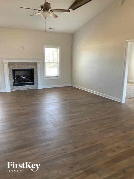 an empty living room with a fireplace and wooden floors