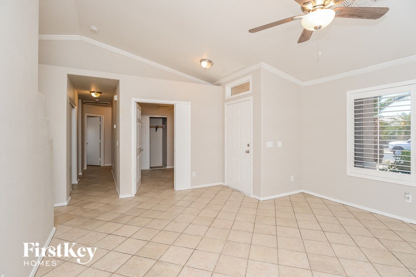 A spacious room with a ceiling fan and tiled flooring.