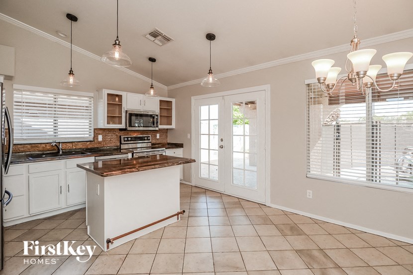 A kitchen with a refrigerator, microwave, and oven.