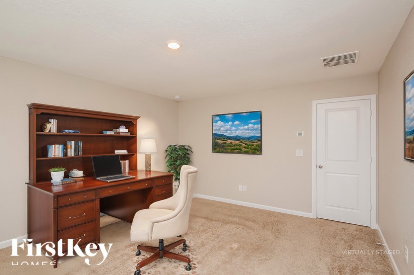 A room with a desk, chair, and bookshelf.