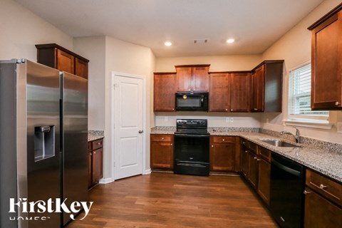 A kitchen with wooden cabinets and a stainless steel refrigerator.