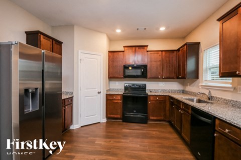 A kitchen with wooden cabinets and a stainless steel refrigerator.