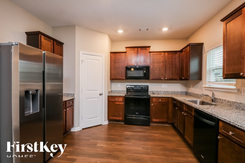 A kitchen with wooden cabinets and a stainless steel refrigerator.