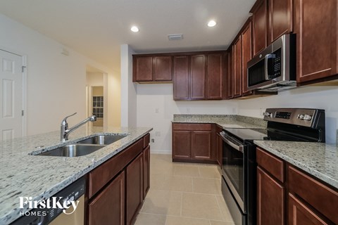 a kitchen with granite counter tops and wooden cabinets