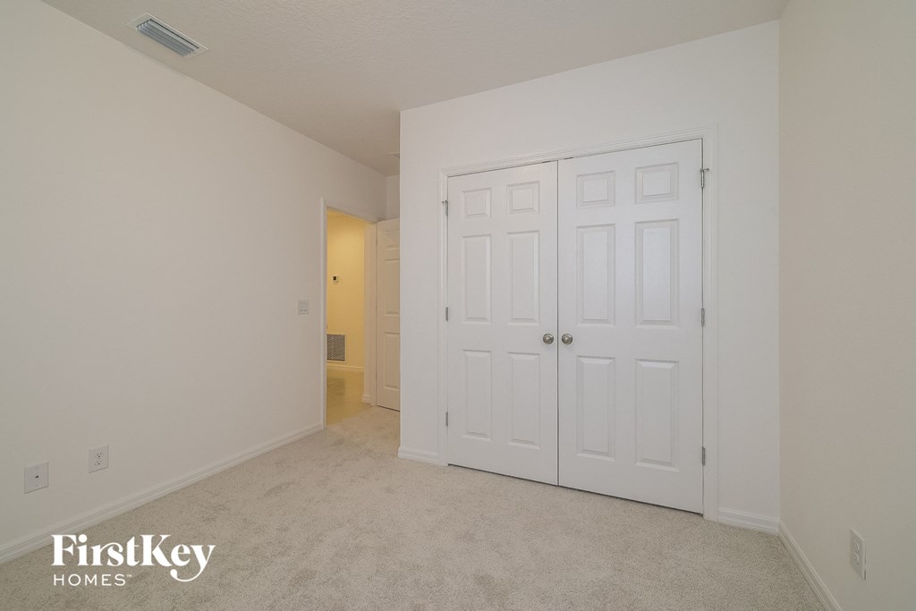 a bedroom with two closets and a carpeted floor