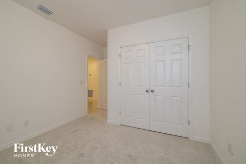 a bedroom with two closets and a carpeted floor