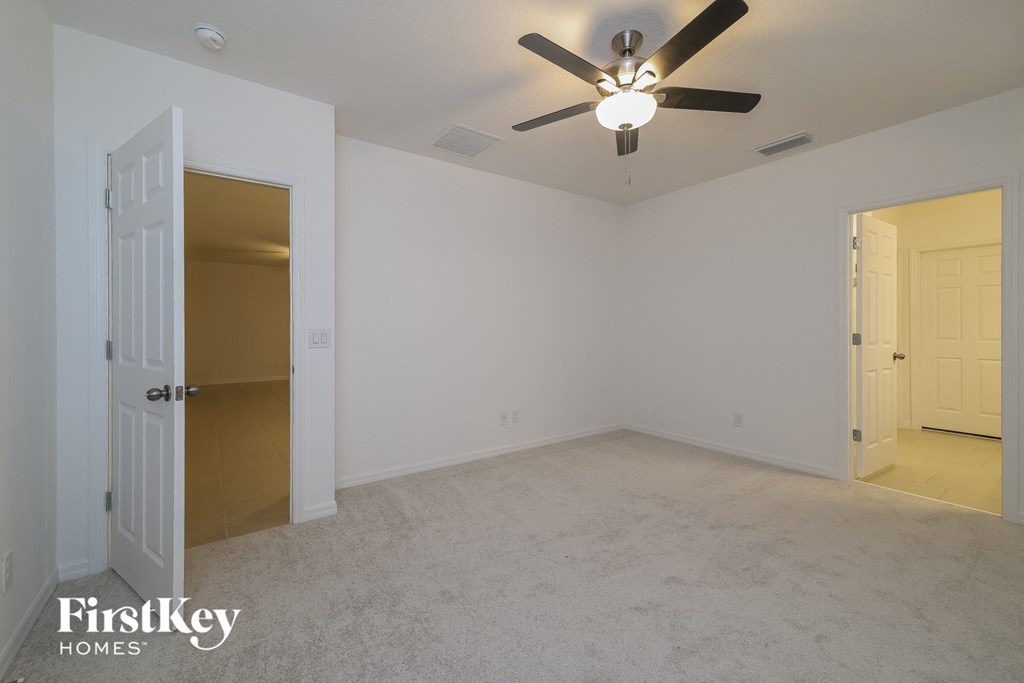 the living room of an empty house with a ceiling fan