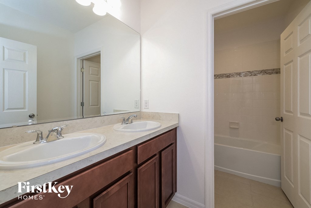a bathroom with two sinks and a shower and a mirror