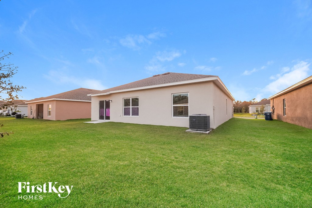 the backyard of a house with a green lawn and a blue sky