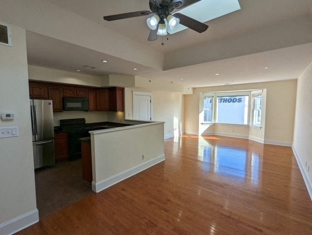 an empty kitchen and living room with a ceiling fan