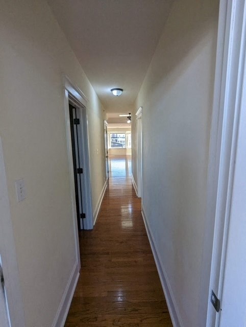 a hallway with a wood floor and white walls