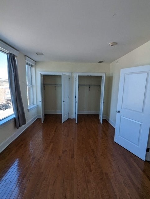 an empty living room with wooden floors and white doors