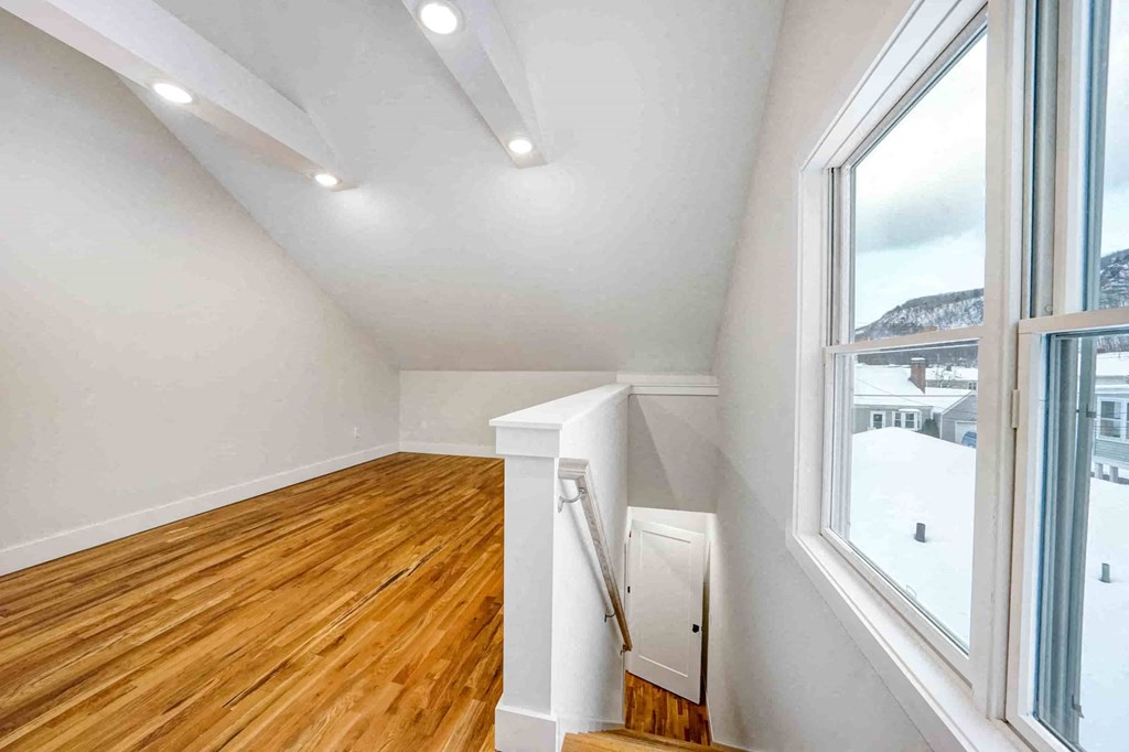 a living room with a wood floor and a large window