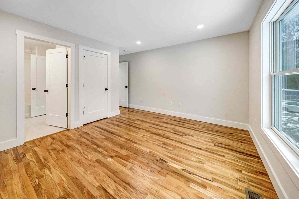 a living room with a hard wood floor and a large window