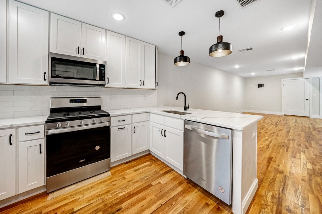 a kitchen with white cabinets and stainless steel appliances
