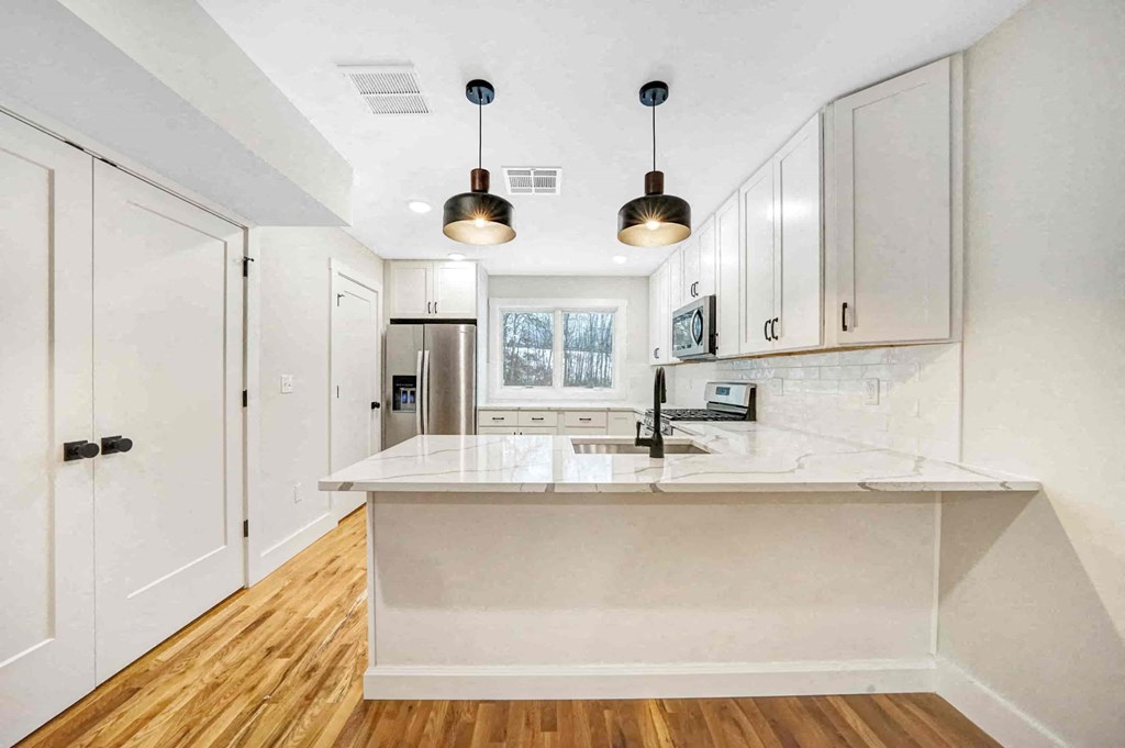 a kitchen with white cabinets and a white counter top