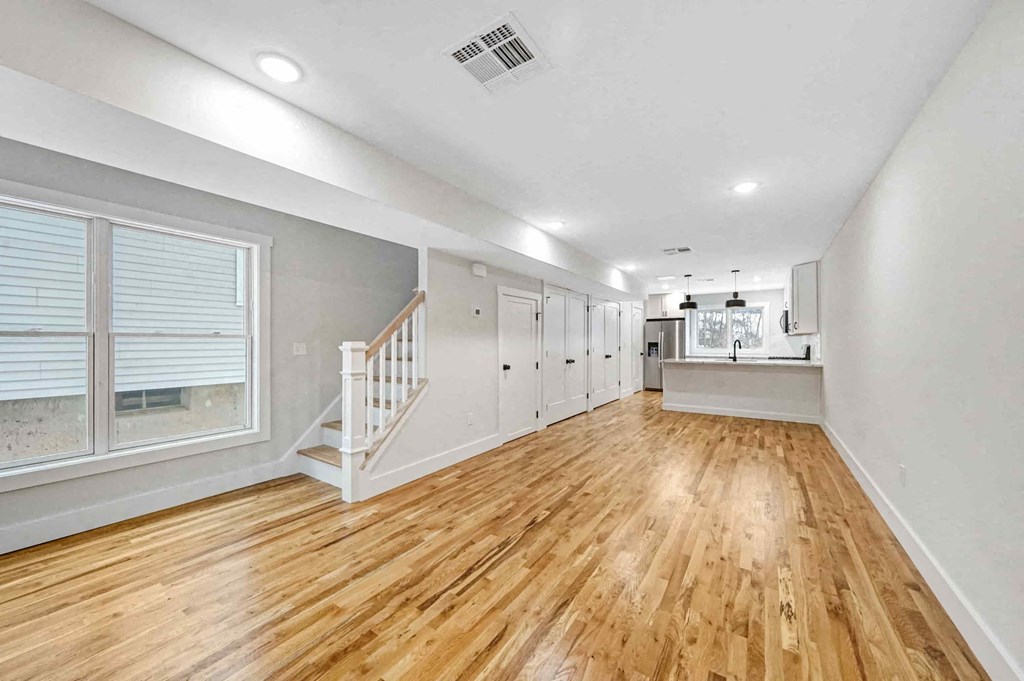 the living room and dining room of a house with a hardwood floor