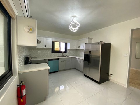 a kitchen with a stainless steel refrigerator and white cabinets