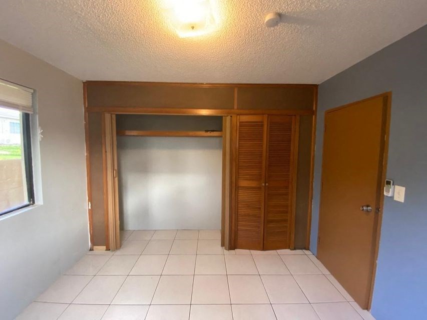 an empty room with a closet and a tile floor