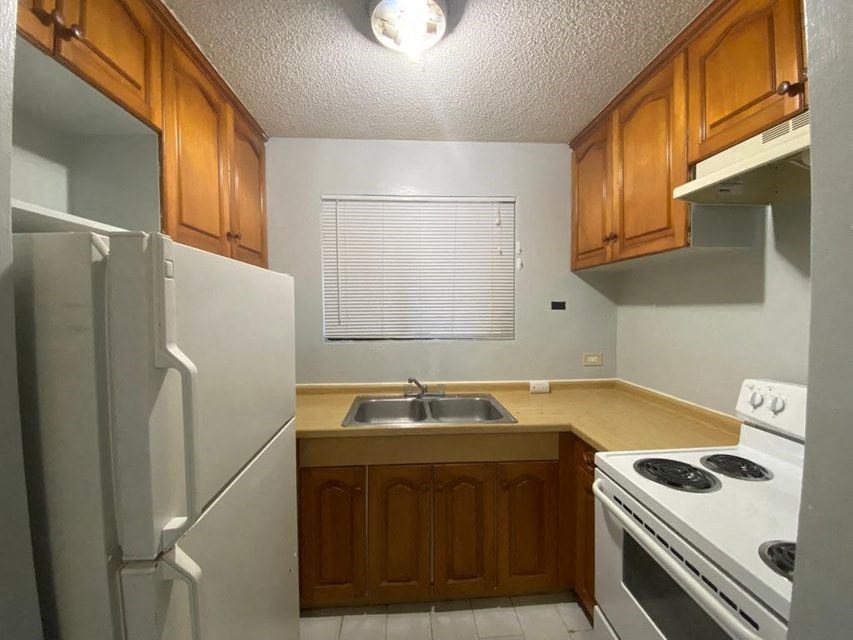 a kitchen with a stove sink and refrigerator