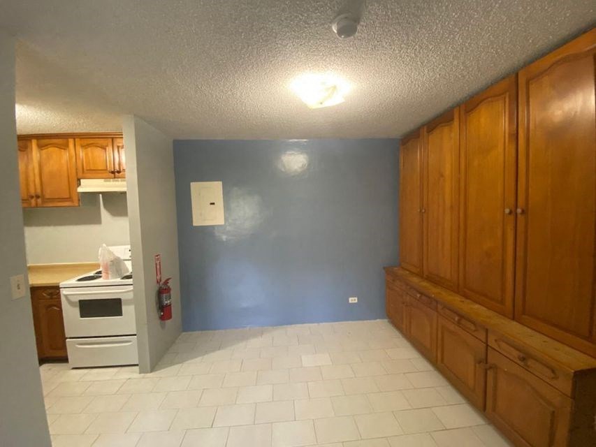 a kitchen with a stove and a blue wall
