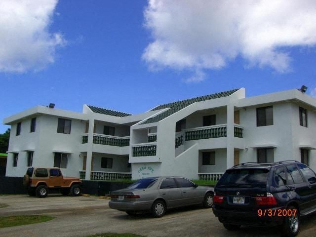 a white apartment building with cars parked in front of it