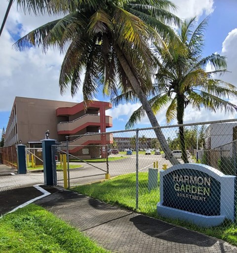 a sign in front of a building with palm trees